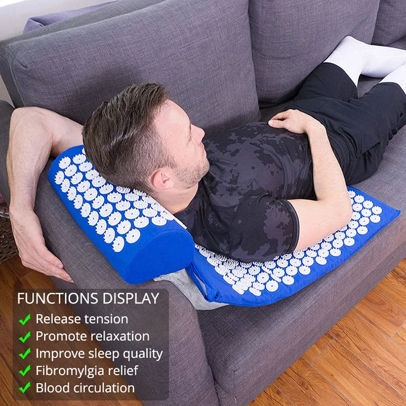 Person lying on a gray couch with an acupressure mat on their back