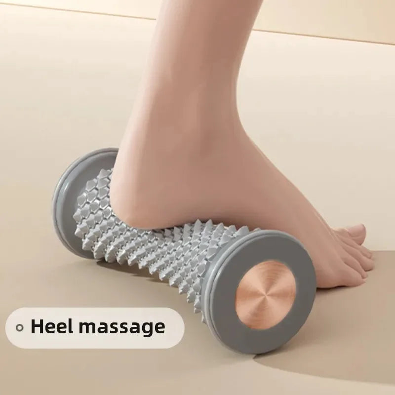Person using a foot roller for heel massage on a light-colored floor.