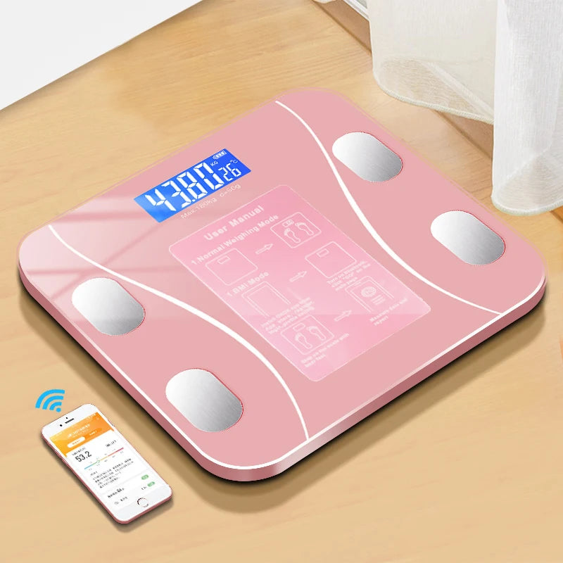 Pink digital body fat scale on a wooden surface with a smartphone displaying app.